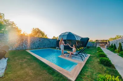 a woman and a child sitting on a bench next to a pool at BALİ Sapanca in Sakarya