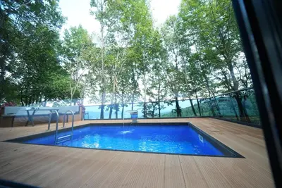 a swimming pool in the middle of a patio with trees at Saklı Vadi Tiny House in Masukiye