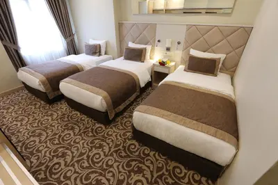 a hotel room with two beds and a window at Alpinn Hotel Istanbul in Istanbul