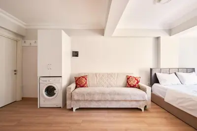 a bedroom with a bed and a couch and a washing machine at aymira hotel pangaltı in Istanbul