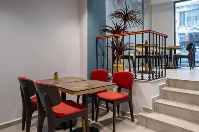 a table and chairs in a room with stairs at Smart and Simple Hotel Karakoy in Istanbul
