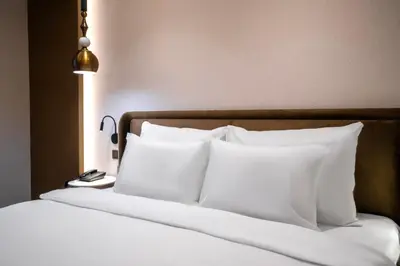 a bedroom with a bed with white pillows and a lamp at Smart and Simple Hotel Karakoy in Istanbul