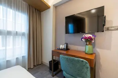 a hotel room with a desk with a vase of flowers at Smart and Simple Hotel Karakoy in Istanbul