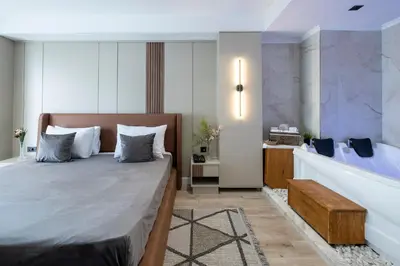 a bedroom with a large bed and a bath tub at Euphrates Hotel Bursa in İhsaniye
