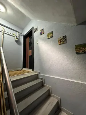 a hallway with stairs with a door and pictures on the wall at ALTAY Airport SUİT in Tayakadın