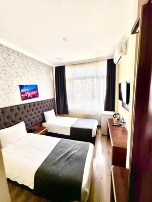 a hotel room with two beds and a television at Grand Ararat Hotel in Istanbul