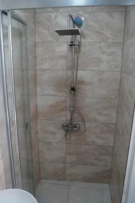 a shower with a glass door and a shower head at Sword Suit Hotel in Istanbul