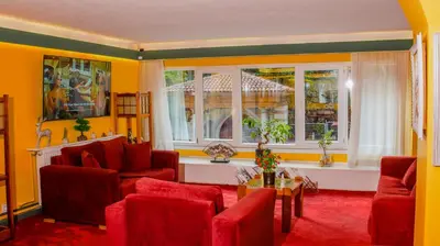 a living room with red furniture and two windows at Mini Harem Hotel in Istanbul