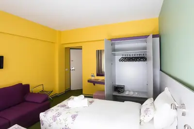 a yellow room with a bed and a purple couch at Mini Harem Hotel in Istanbul