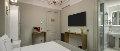 a bathroom with a bed and a sink and a tv at Komana Hotel Binbirdirek in Istanbul