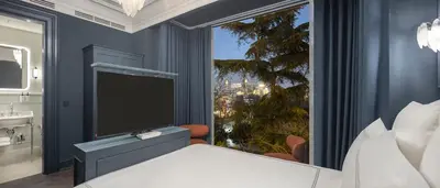 a bedroom with a large window with a flat screen tv at Komana Hotel Binbirdirek in Istanbul