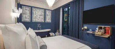 a blue bedroom with a bed and a bath tub at Komana Hotel Binbirdirek in Istanbul