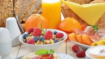 a table topped with bowls of cereal and fruit at Hotel Suadiye in Istanbul
