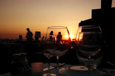 two wine glasses on a table with the sunset in the background at Hotel Suadiye in Istanbul