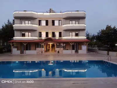 a building with a swimming pool in front of it at Bayramoğlu Suite in Darıca