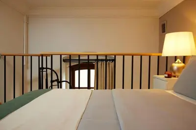 a bedroom with a bed and a table with a lamp at Historic High-Ceiling 2-Flat Combo - Taksim in Istanbul