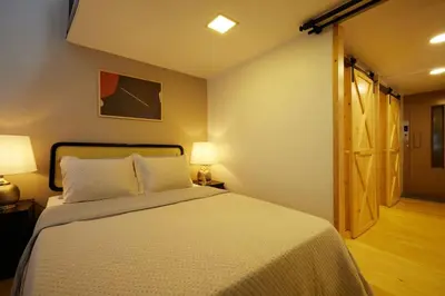a bedroom with a bed with two lamps and a door at Historic High-Ceiling 2-Flat Combo - Taksim in Istanbul