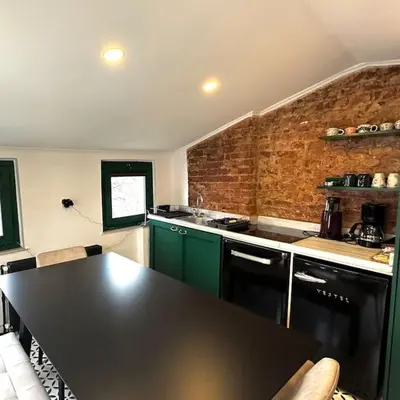 a kitchen with green cabinets and a black counter top at Beyoğlu'nda dubleks tarihi daire in Istanbul