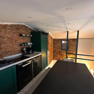 a kitchen with green cabinets and a black counter top at Beyoğlu'nda dubleks tarihi daire in Istanbul