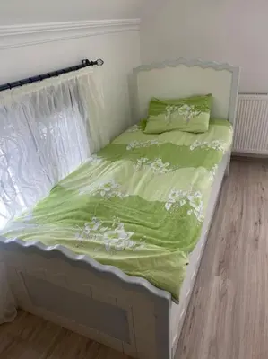 a bed with a green comforter and a window at Tuzlada Ferah Alani Havuz,Bahçe ve tüm rahatlıklar kişiye özel alan in Tuzla