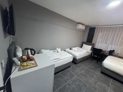 a hotel room with two beds and a table with a table at Old City Kadıköy Otel in Istanbul