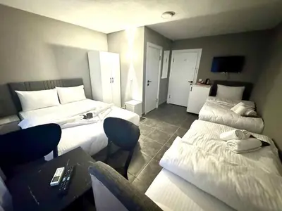 a hotel room with two beds and a table at Old City Kadıköy Otel in Istanbul