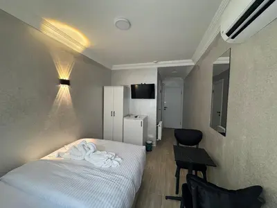 a bedroom with a bed and a table and a chair at Old City Kadıköy Otel in Istanbul