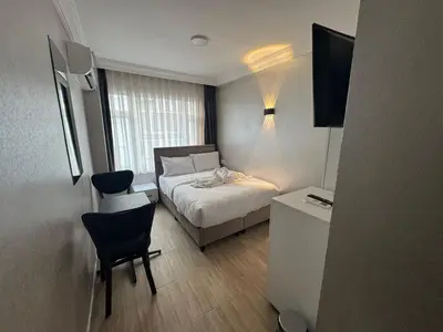a small bedroom with a bed and a table and chairs at Old City Kadıköy Otel in Istanbul