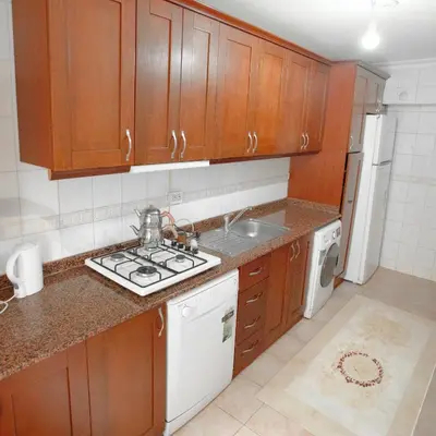a kitchen with wooden cabinets and a sink and a stove at New furniture, zero air conditioning, modern and quiet 19 in Istanbul