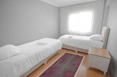 a bedroom with two beds and a table and a window at Large central apartment in a quiet area 40 in Istanbul
