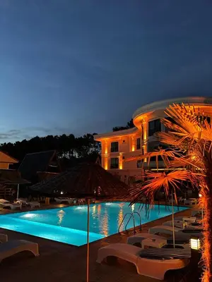 a large building with a swimming pool at night at Kerpe Bungalov Hotel in Kandıra