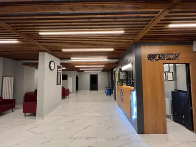 a hallway in a building with a lobby with red chairs at Hotel Prima in Istanbul