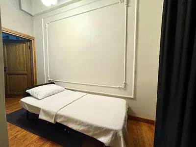 a small bed in a room with a large wall at Mansion Istanbulite in Istanbul