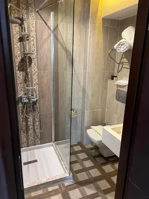 a bathroom with a shower and a toilet and a sink at Nacre Boutique Residence in Istanbul