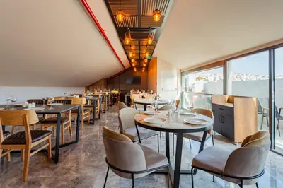 a restaurant with tables and chairs and windows at Atm Suit Otel in Istanbul