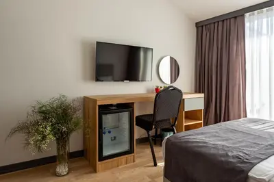 a bedroom with a desk with a television and a chair at Atm Suit Otel in Istanbul