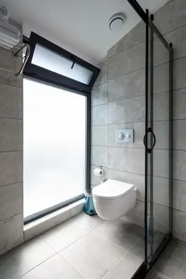 a bathroom with a toilet and a large window at Atm Suit Otel in Istanbul
