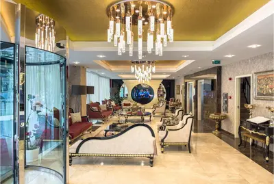 a lobby with a table and chairs and a chandelier at The Conforium Hotel İstanbul in Istanbul