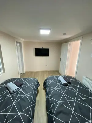 a bedroom with two beds and a flat screen tv at ilkim&derin suite in Istanbul