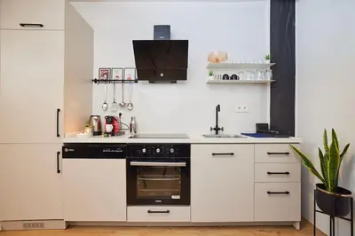 a kitchen with white cabinets and a black stove top oven at Stunning Apartment at Unbeatable Location in Istanbul