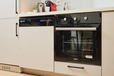 a black oven in a white kitchen at Stylish 2BR Apt Galata-Taksim Area Near Metro in Istanbul