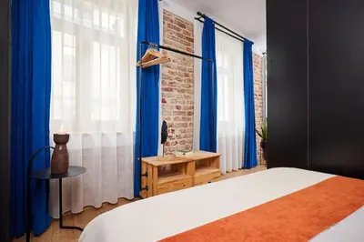 a bedroom with blue curtains and a bed with a table at Stylish 2BR Apt Galata-Taksim Area Near Metro in Istanbul