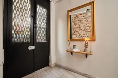 a hallway with a black door and a mirror at Modern 2BR Apt Galata-Taksim Area Near Metro in Istanbul