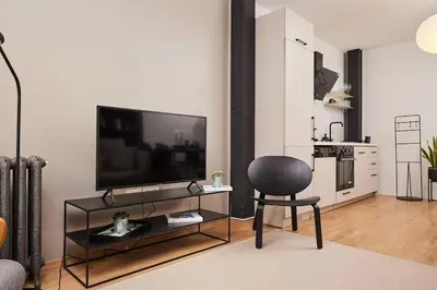 a living room with a television and a chair at Modern 2BR Apt Galata-Taksim Area Near Metro in Istanbul