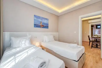 a bedroom with two beds and a dining room with a table at Port Apart Hotel in Istanbul