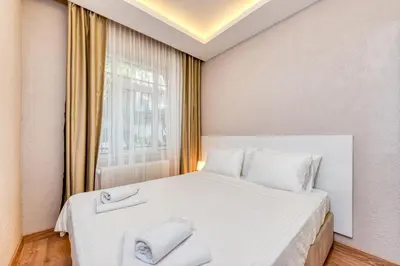 a bedroom with a white bed with two towels on it at Port Apart Hotel in Istanbul