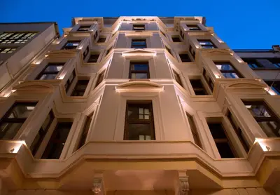 a tall white building with windows at night at Taxim Lounge Hotel Special Category in Istanbul