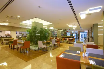 a restaurant with tables and chairs in a building at Ramada By Wyndham İstanbul Taksim in Istanbul