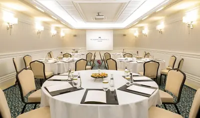 a conference room with tables and chairs and a podium at Metropolitan Hotels Taksim in Istanbul