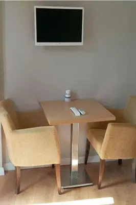 a wooden table with two chairs and a television at NO PROBLEM OTEL Pansiyon in Tekirdag